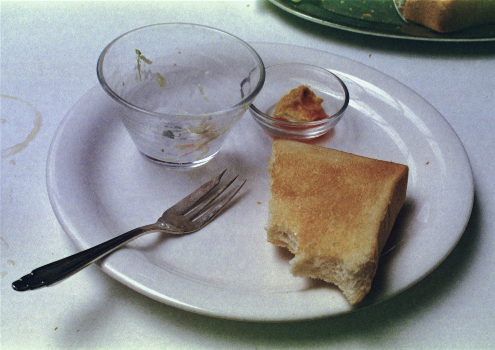 食べかけのパンと空のグラスが残る皿