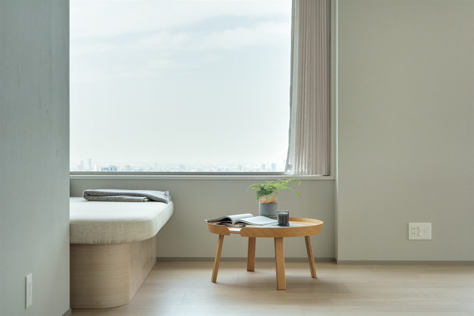 窓辺のベンチと小さなテーブルがある明るい部屋